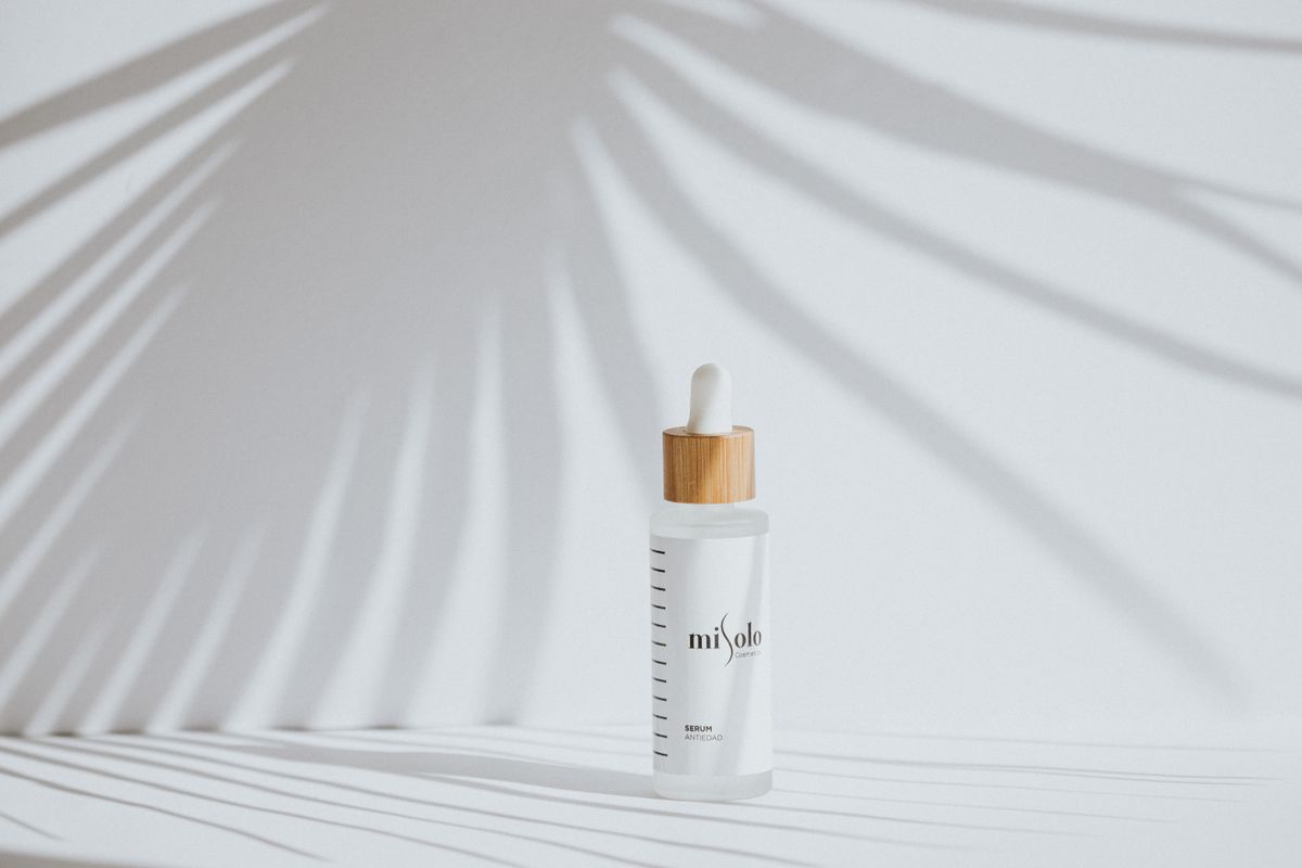 White facial mist spray bottle on a plain surface
