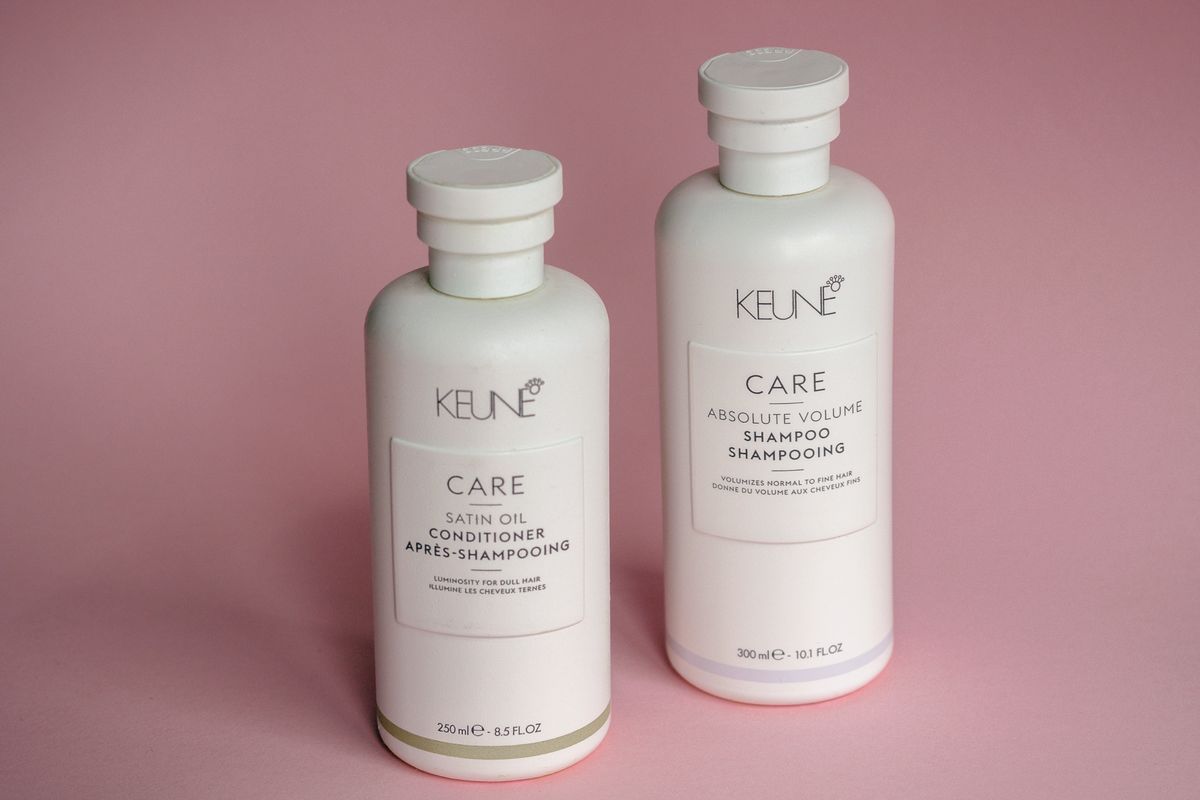 Clear shampoo bottle pouring a pearl of lather into a wet hand