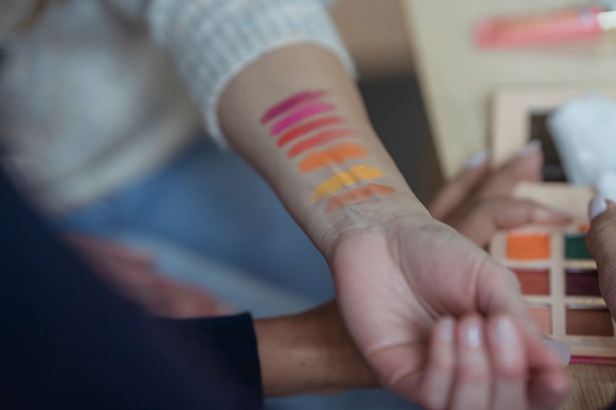 A row of foundation swatches applied along a woman's jawline in daylight